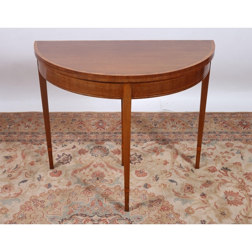 68 - A SHERATON DESIGN MAHOGANY AND CROSSBANDED FOLDOVER CARD TABLE of demi lune outline the hinged top c... 