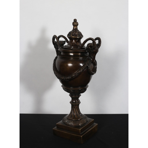 109 - A BRONZE LIDDED URN with ram head figural masks hung with garlands above a waisted sockle on stepped... 