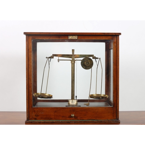 110 - A VINTAGE BRASS LABORATORY SCALES in mahogany and glazed case 
Bears plaque 'W. & J. George Limited ... 