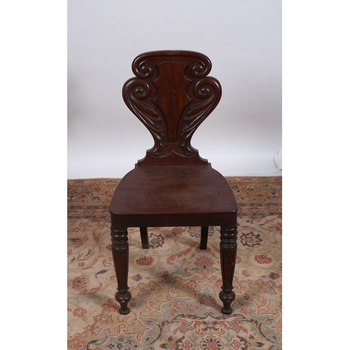 246 - A 19TH CENTURY MAHOGANY HALL CHAIR the foliate scroll carved back and panelled seat on baluster legs