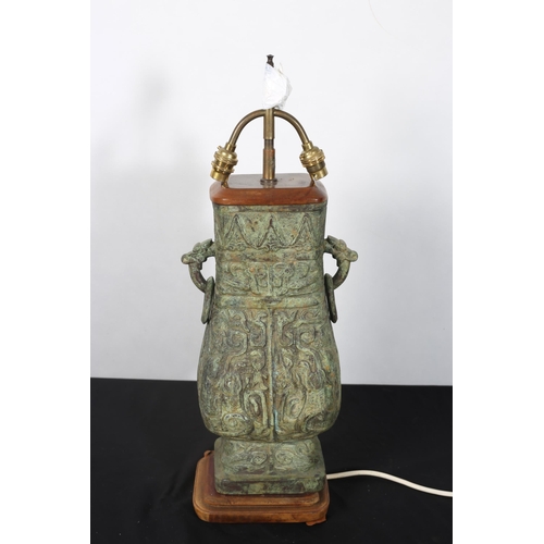 287 - A CHINESE BRONZE TWO BRANCH TABLE LAMP of vase form moulded in relief with figural mask and ring han... 