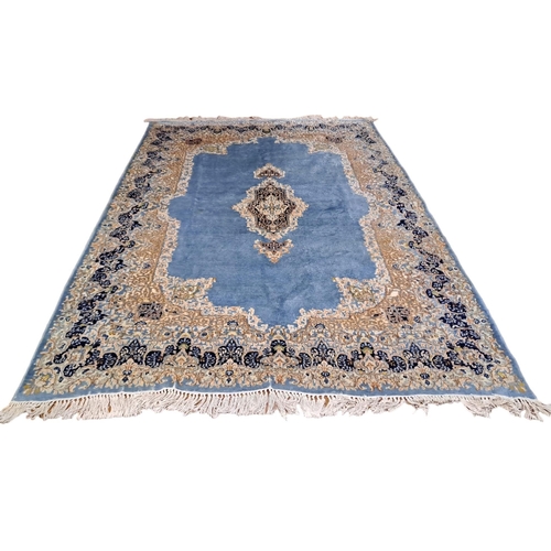 326 - A KERMAN WOOL RUG the light blue beige and indigo ground with central panel filled with stylised flo... 