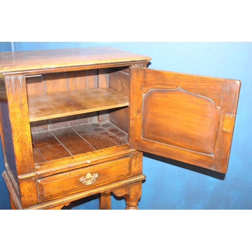 329 - A JACOBEAN STYLE OAK CABINET of rectangular outline the shaped top above a shaped panel door with br... 