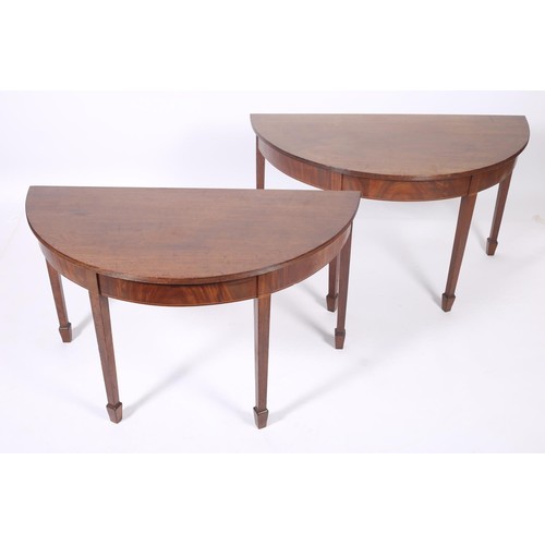 386 - A PAIR OF GEORGIAN MAHOGANY SIDE TABLES each of demilune outline with reeded rim above a moulded apr... 