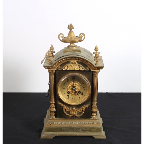 107 - A CONTINENTAL GILT BRASS MANTEL CLOCK the rectangular arched case surmounted by a neo-classical urn ... 