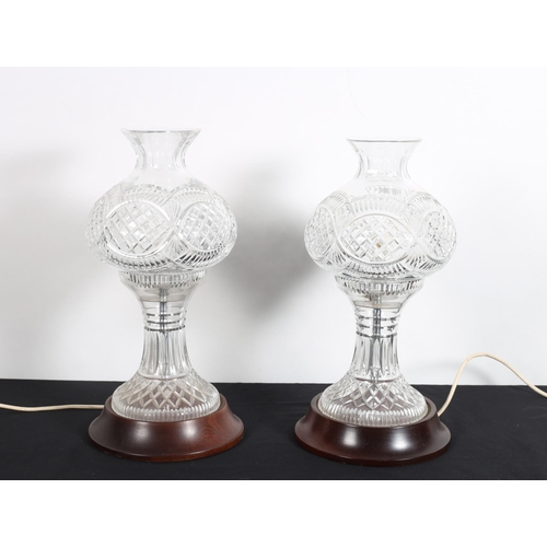 122 - A PAIR OF CUT GLASS TABLE LAMPS each with a globe shaped shade above a waisted column on spreading f... 