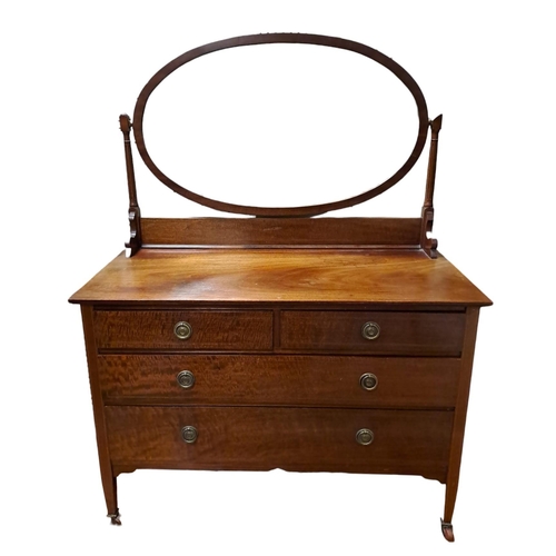 167 - A VINTAGE MAHOGANY DRESSING TABLE the oval bevelled glass plate raised on fluted supports above two ... 