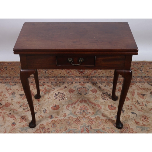 179 - A GEORGIAN MAHOGANY FOLDOVER SUPPER TABLE the rectangular hinged top with frieze drawer on cabriole ... 