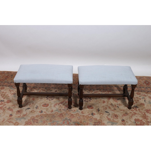 190 - A PAIR OF STAINED BEECHWOOD AND UPHOLSTERED STOOLS each with a rectangular upholstered seat on balus... 