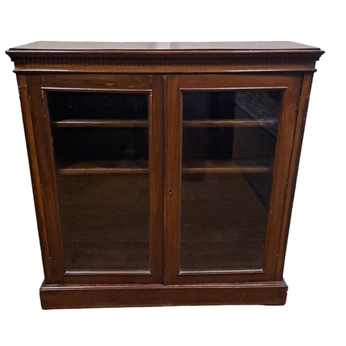 328 - A VINTAGE MAHOGANY BOOKCASE of rectangular outline the shaped top with dentil moulded frieze above a... 