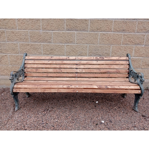 332 - A VICTORIAN STYLE CAST IRON AND PINE GARDEN BENCH the slatted back and shaped seat on pierced foliat... 