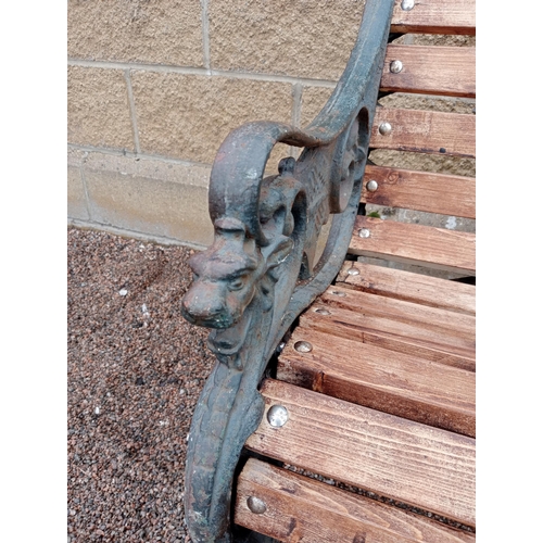 332 - A VICTORIAN STYLE CAST IRON AND PINE GARDEN BENCH the slatted back and shaped seat on pierced foliat... 