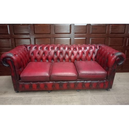 355 - A VICTORIAN STYLE HIDE UPHOLSTERED SETTEE the deep buttoned scroll over back and arms with loose cus... 