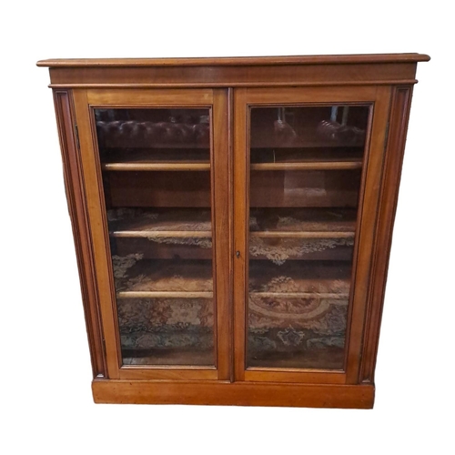 356 - A VINTAGE MAHOGANY BOOKCASE of rectangular outline the shaped top above a pair of glazed doors conta... 