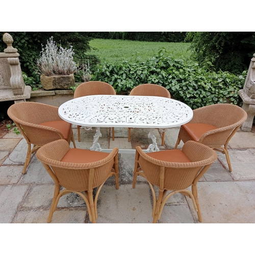 368 - A CAST METAL AND RATTAN SEVEN PIECE PATIO SUITE comprising an oval top table with pierced foliate de... 