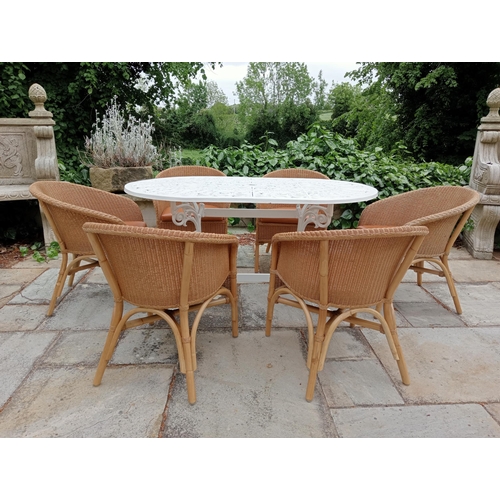 368 - A CAST METAL AND RATTAN SEVEN PIECE PATIO SUITE comprising an oval top table with pierced foliate de... 