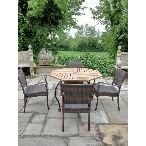 369 - A FIVE PIECE WROUGHT IRON RATTAN AND OAK PATIO SUITE comprising four elbow chairs each with a woven ... 