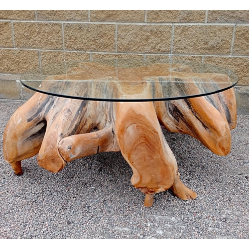 371 - A MIDI WOOD AND GLAZED COFFEE TABLE the circular glazed top on carved base of irregular outline 
50c... 