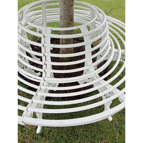 372 - A WROUGHT IRON AND TUBULAR TREE SEAT of cylindrical outline with tubular splats and seat on pierced ... 