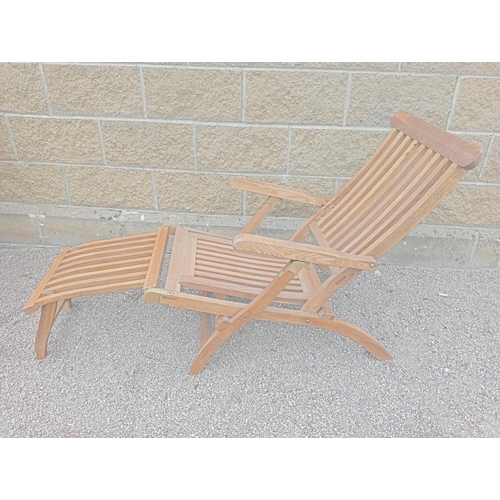 374 - A TEAK AND BRASS MOUNTED SUNLOUNGER with slatted back and seat and shaped arms with footrest 
85cm (... 