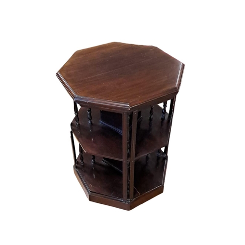 375 - AN EDWARDIAN MAHOGANY REVOLVING BOOKSTAND of octagonal outline the shaped top above open compartment... 