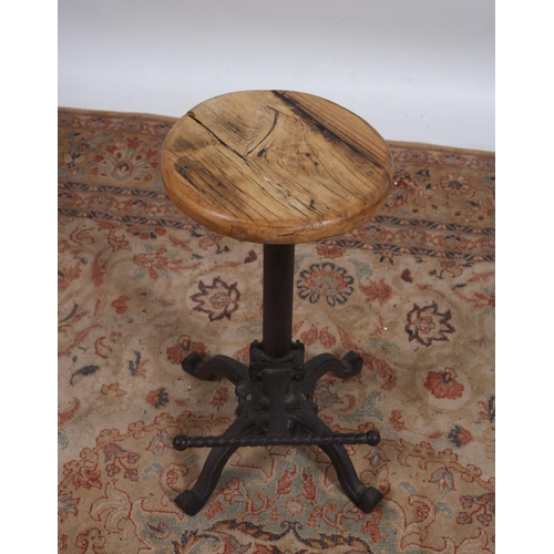 410 - A WROUGHT IRON AND PINE REVOLVING STOOL the circular seat above a cylindrical column on quadruped sp... 