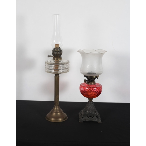 415 - A VINTAGE BRASS AND CLEAR GLASS OIL LAMP with reeded column above a circular spreading foot together... 