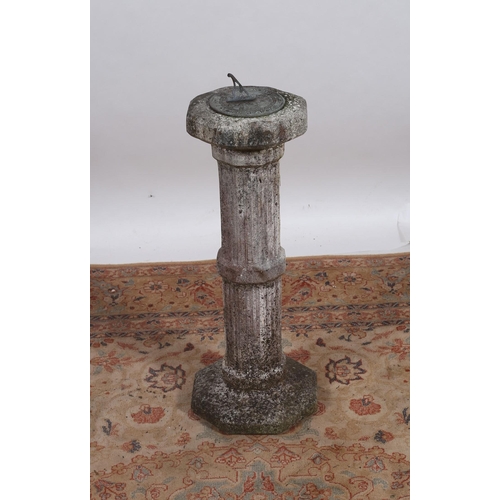 62 - A SANDSTONE SUNDIAL with bronze dial the octagonal shaped top above a fluted column on spreading foo... 