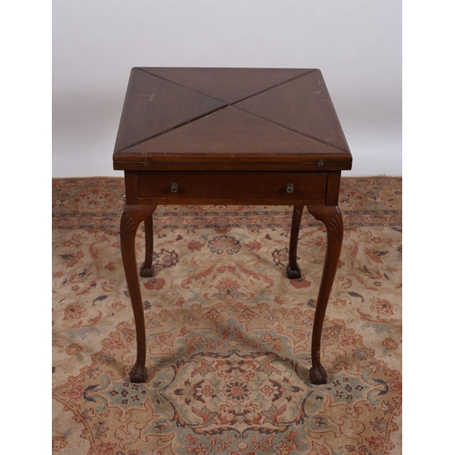 86 - A VINTAGE MAHOGNAY ENVELOPE CARD TABLE of square outline the shaped top with hinged leaves containin... 