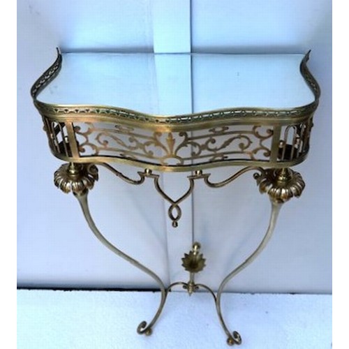 314 - A CONTINENTAL GILT BRASS AND GLAZED CONSOLE TABLE c.1960s of serpentine outline the pierced gallery ... 