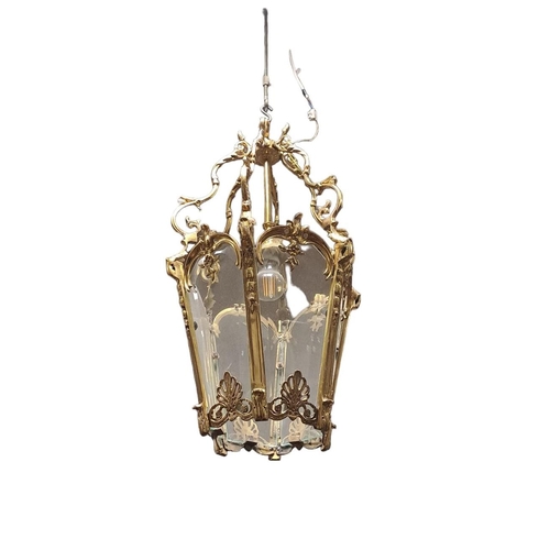 343 - A GILT BRASS AND GLAZED SINGLE LIGHT HALL LANTERN of octagonal tapering form hung with C-scroll arms... 