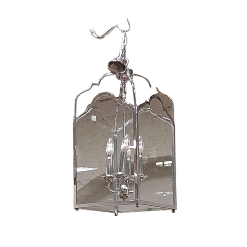 350 - A CHROME AND GLAZED FOUR LIGHT LANTERN of square form hung with scroll arms and link chain suspensio... 