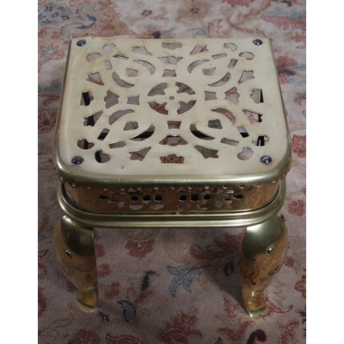 465 - A 19TH CENTURY PIERCED BRASS TRIVET of rectangular outline raised on scroll legs 34cm (h) x 40cm (w)... 