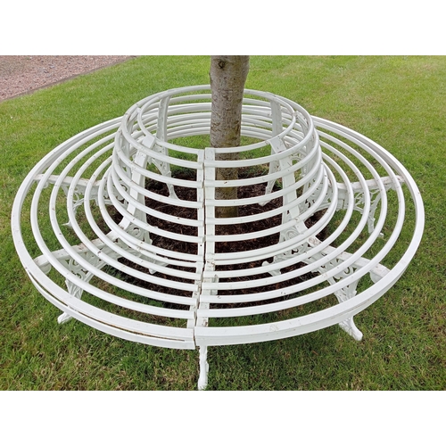 712 - A WROUGHT IRON AND TUBULAR TREE SEAT of cylindrical outline with tubular splats and seat on pierced ... 