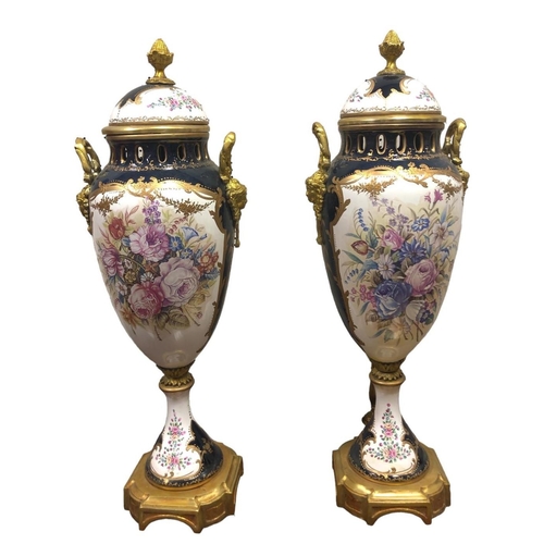 104 - A PAIR OF CONTINENTAL PORCELAIN GILT BRASS MOUNTED LIDDED URNS each of vase form the white, blue and... 