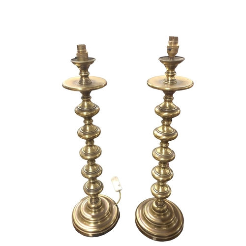 105 - A PAIR OF BRASS TABLE LAMPS each with a knopped column raised on a circular spreading foot with shad... 