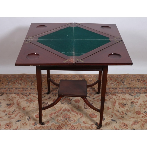 241 - AN EDWARDIAN MAHOGANY ENVELOPE CARD TABLE the square moulded top with hinged leaves containing baize... 