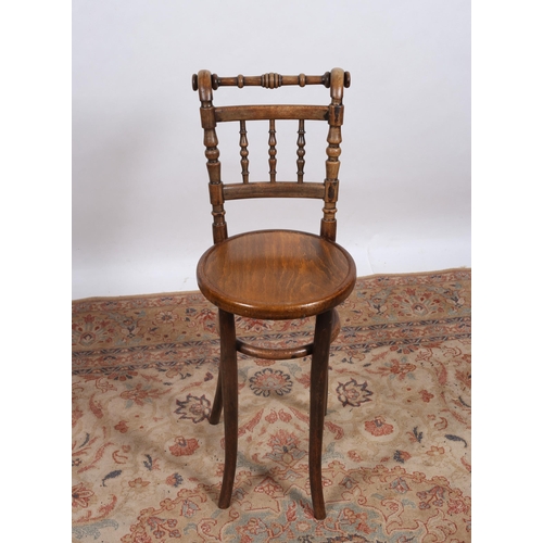 246 - A VINTAGE BENTWOOD MUSIC CHAIR the turned top rail above baluster stretchers with panelled seat on c... 