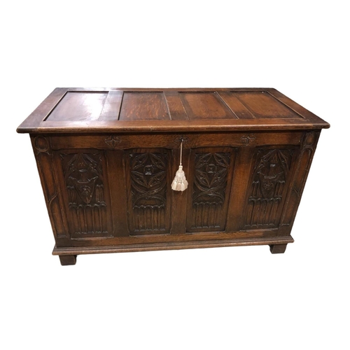 25 - A VINTAGE OAK COFFER the rectangular hinged top with recessed panels above a carved panel apron on s... 