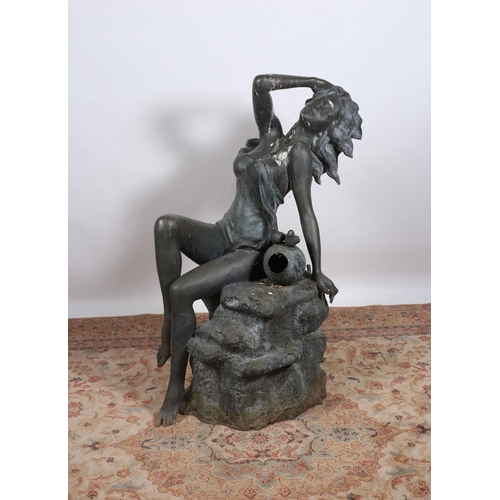 257 - A BRONZE FOUNTAIN modelled as a female shown seated on a rockwork base 127cm (h)