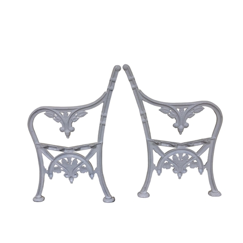 267 - A PAIR OF CAST IRON SEAT ENDS with stylised foliage and scroll decoration on splayed legs with pad f... 