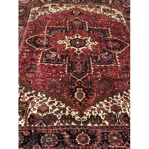 338 - AN ORIENTAL WOOL RUG the beige, wine and indigo ground with central panel filled with stylised flowe... 