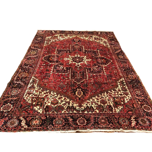 338 - AN ORIENTAL WOOL RUG the beige, wine and indigo ground with central panel filled with stylised flowe... 