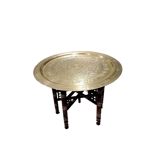 360 - A BRASS BENARES TRAY on a folding stand 45cm (h) x 60cm (d)