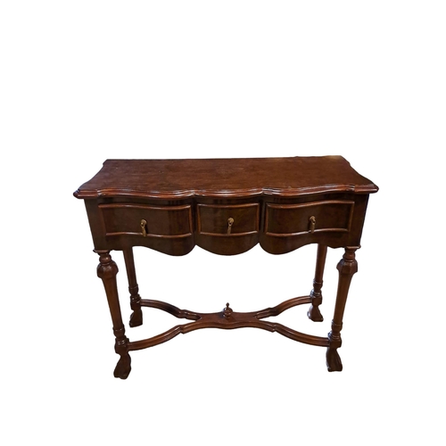 364 - A CONTINENTAL WALNUT SIDE TABLE of serpentine outline the shaped top with three frieze drawers on cy... 