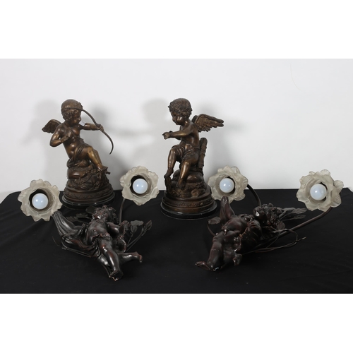 372 - A PAIR OF BRONZE FIGURES each modelled as a cupid shown seated on a rockwork base with marble plinth... 