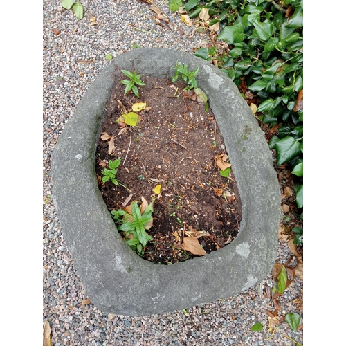 727 - A STONE TROUGH of oval outline 40cm (h) x 80cm (w) x 65cm (d)