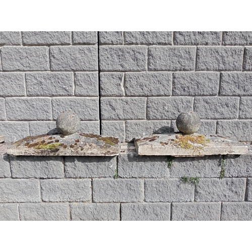 430 - A PAIR OF COMPOSITION STONE PIER CAPS each of rectangular form with spherical finial 40cm (h) x 90cm... 