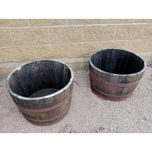 437 - A PAIR OF OAK AND STEEL BOUND BARRELS of cylindrical tapering form 43cm (h) x 64cm (d)