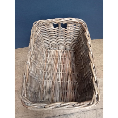 439 - A WICKER LOG BASKET of rectangular form with carrying handles 60cm (h) x 92cm (w) x 62cm (d)